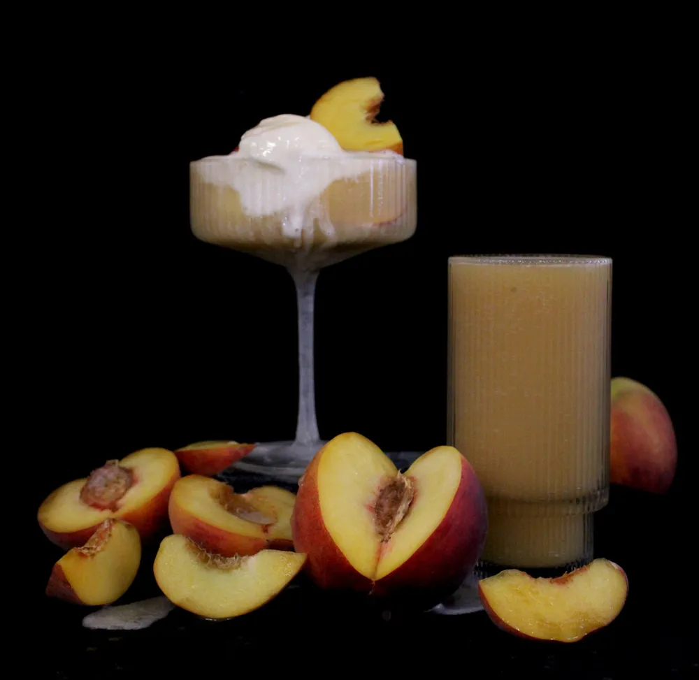 A dessert-style Ceremony Brewing beer composition with fresh peaches on a dark background